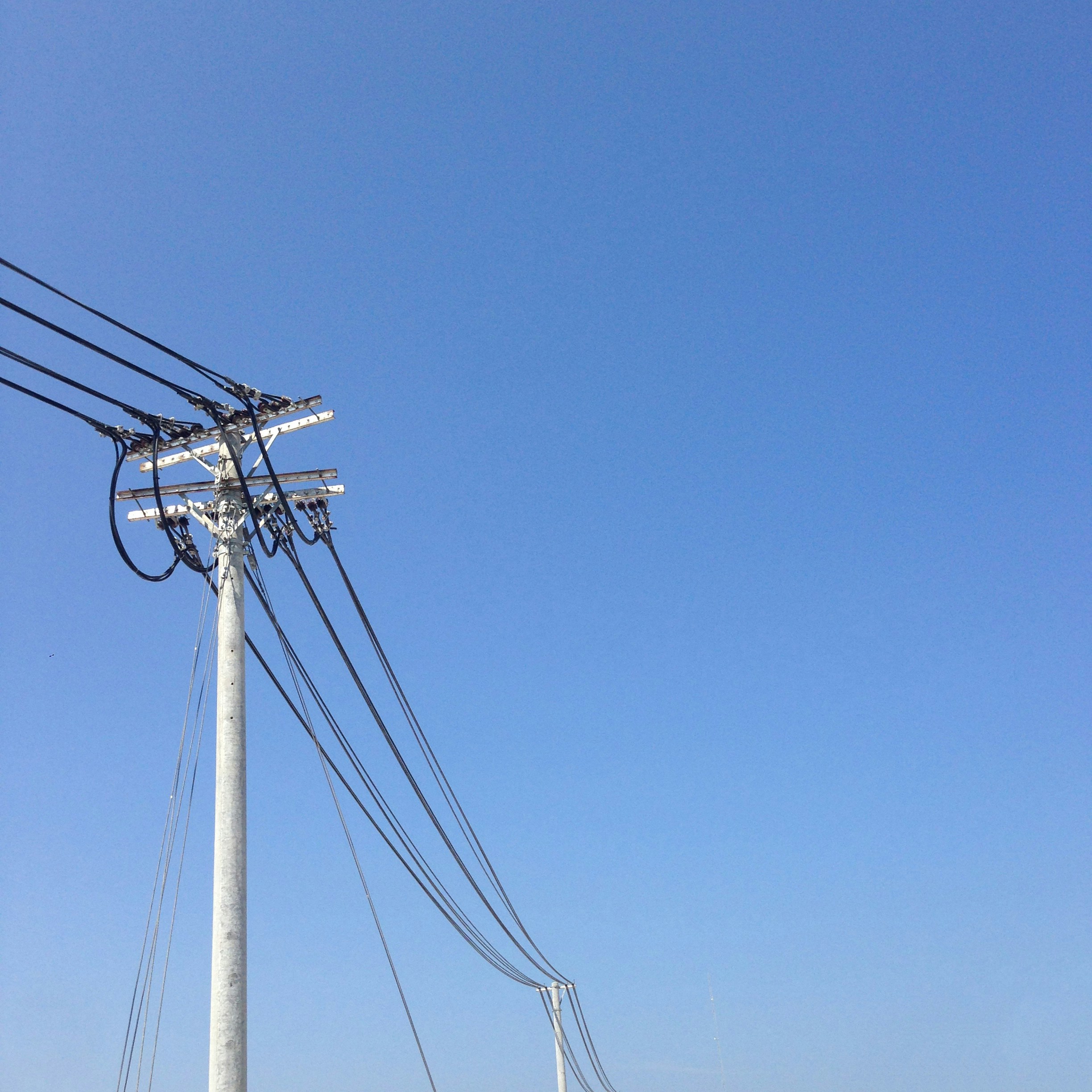 palo elettrico bianco sotto il cielo blu durante il giorno