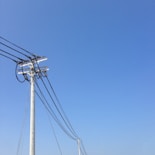 white electric post under blue sky during daytime