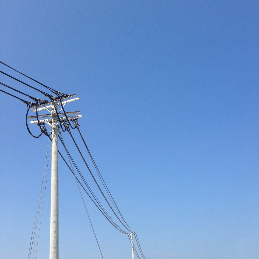 white electric post under blue sky during daytime