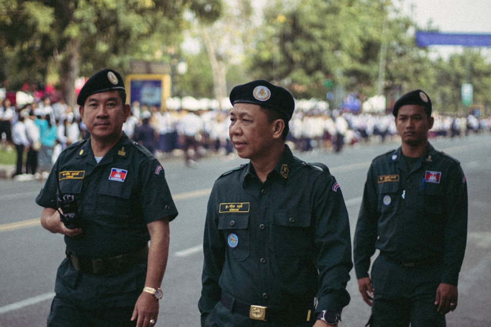 man in black police uniform standing on field during daytime