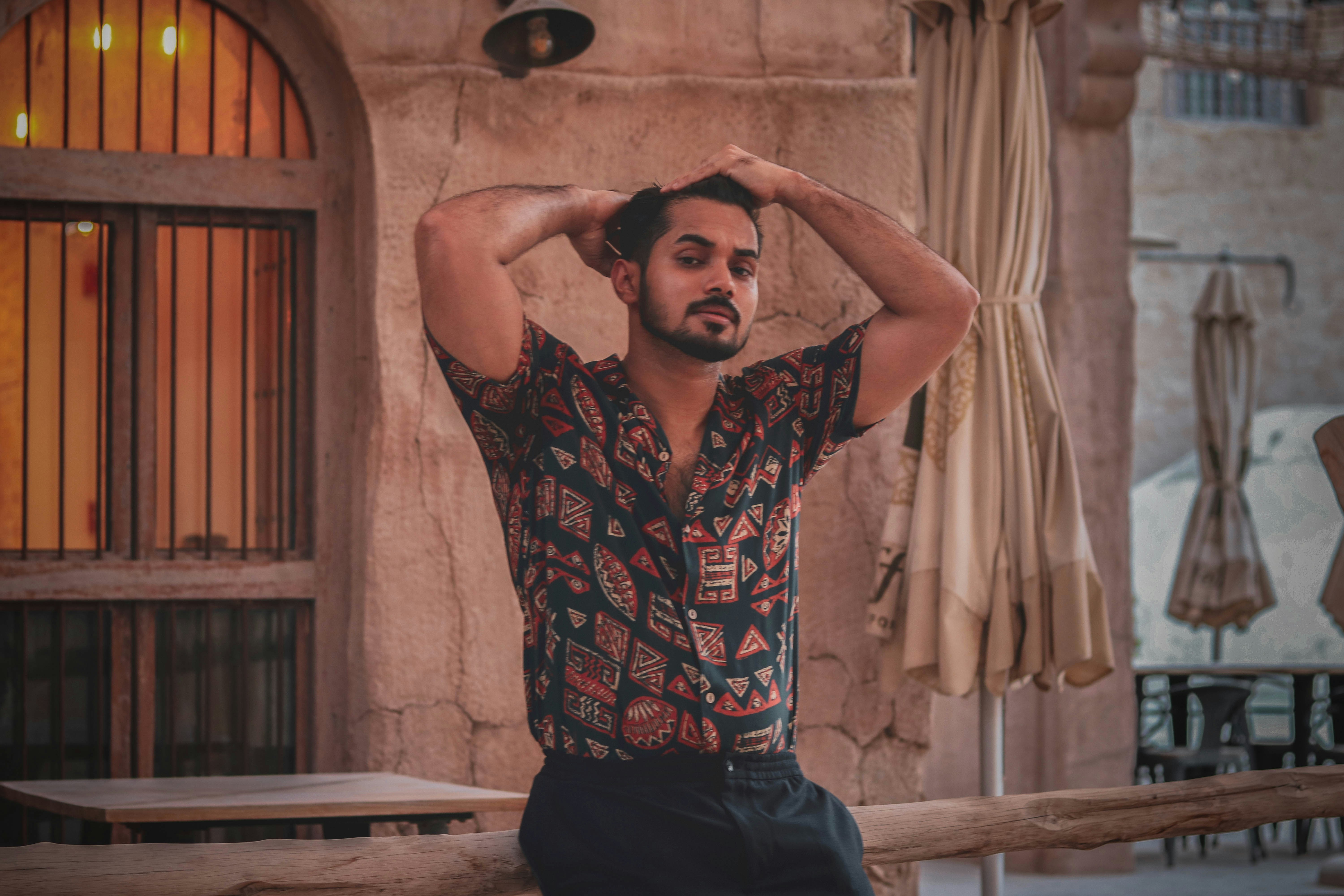 man in black and red floral button up shirt and black denim jeans