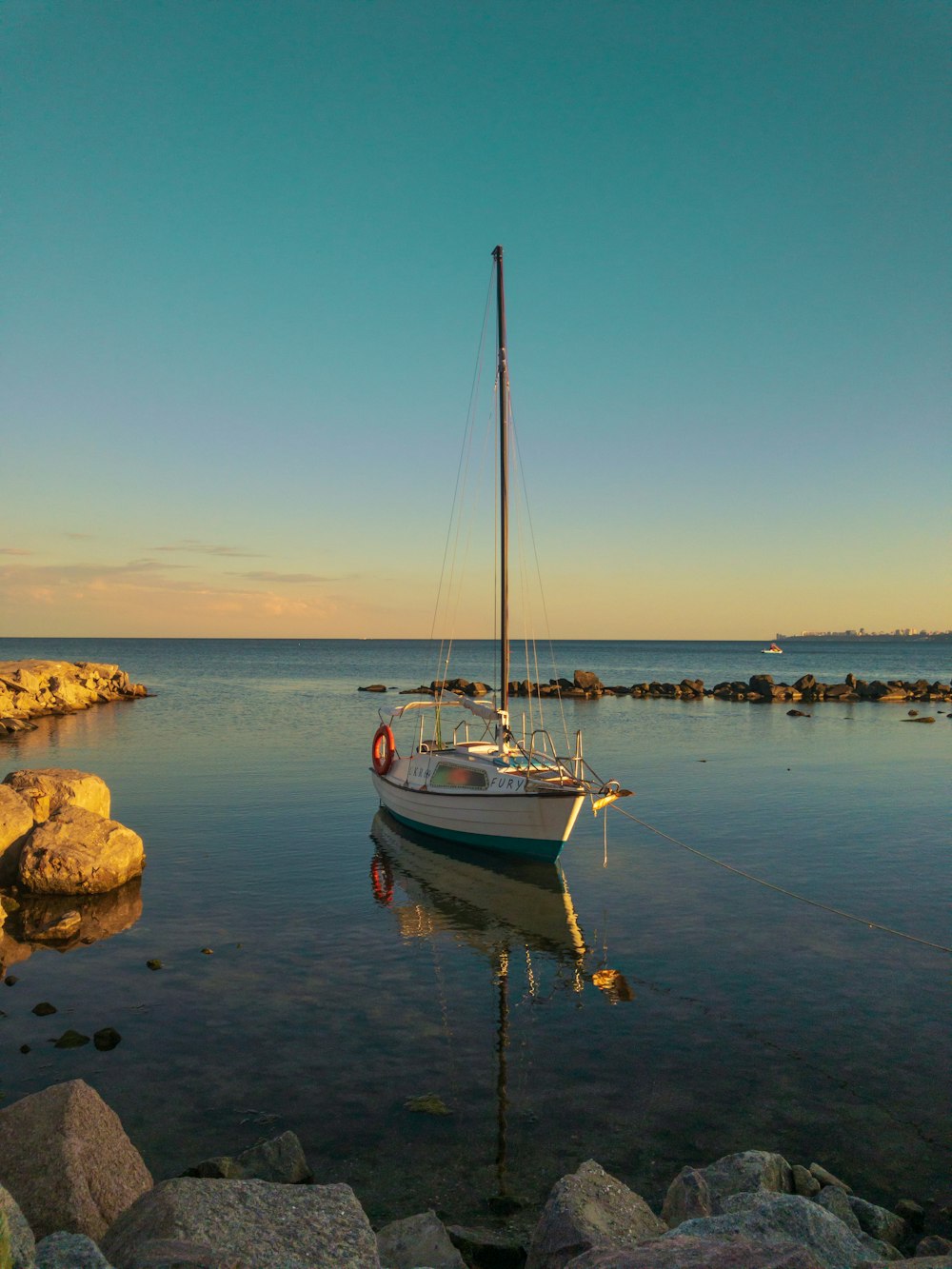 white and blue boat on sea shore during daytime