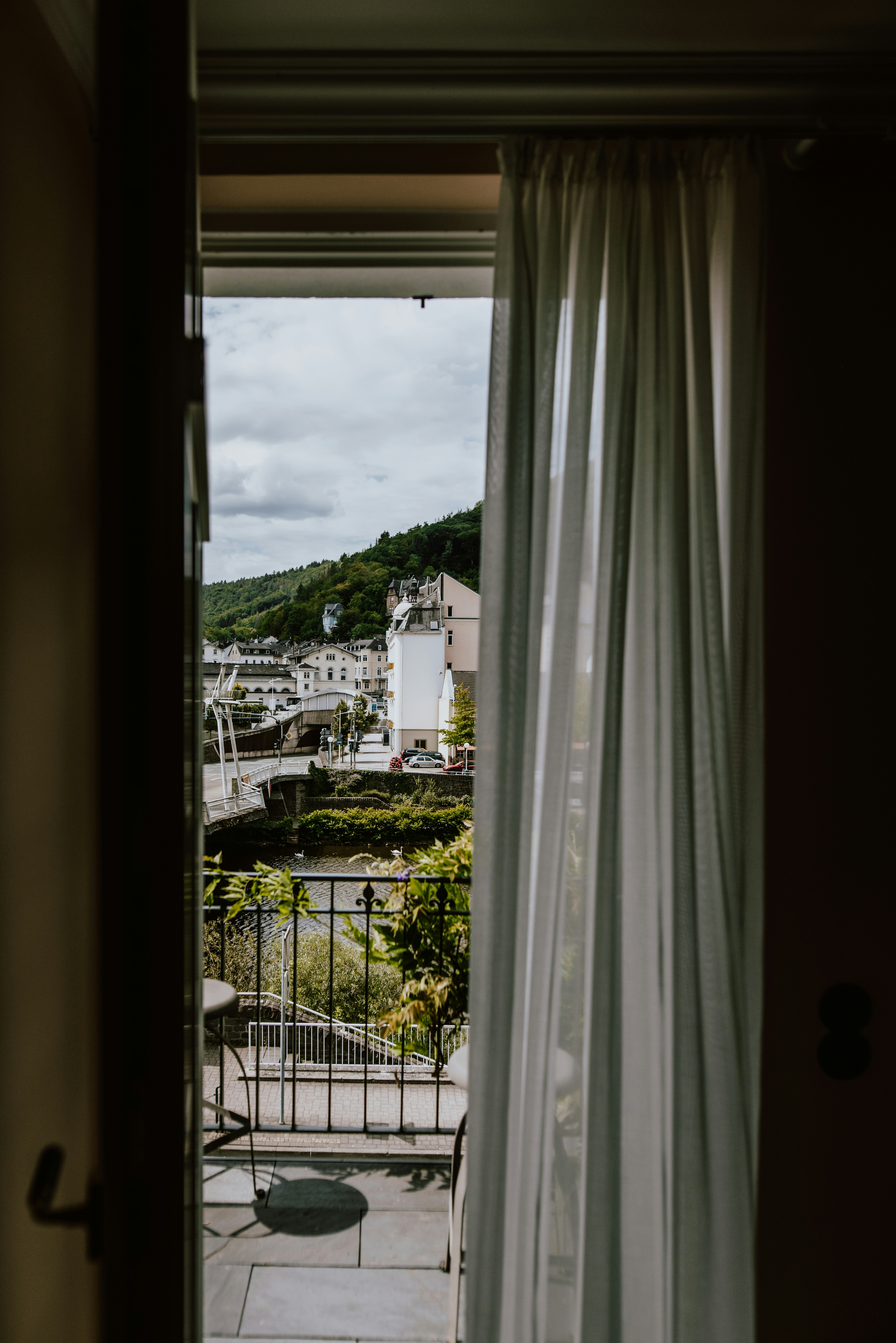weißer Fenstervorhang in der Nähe grüner Bäume tagsüber