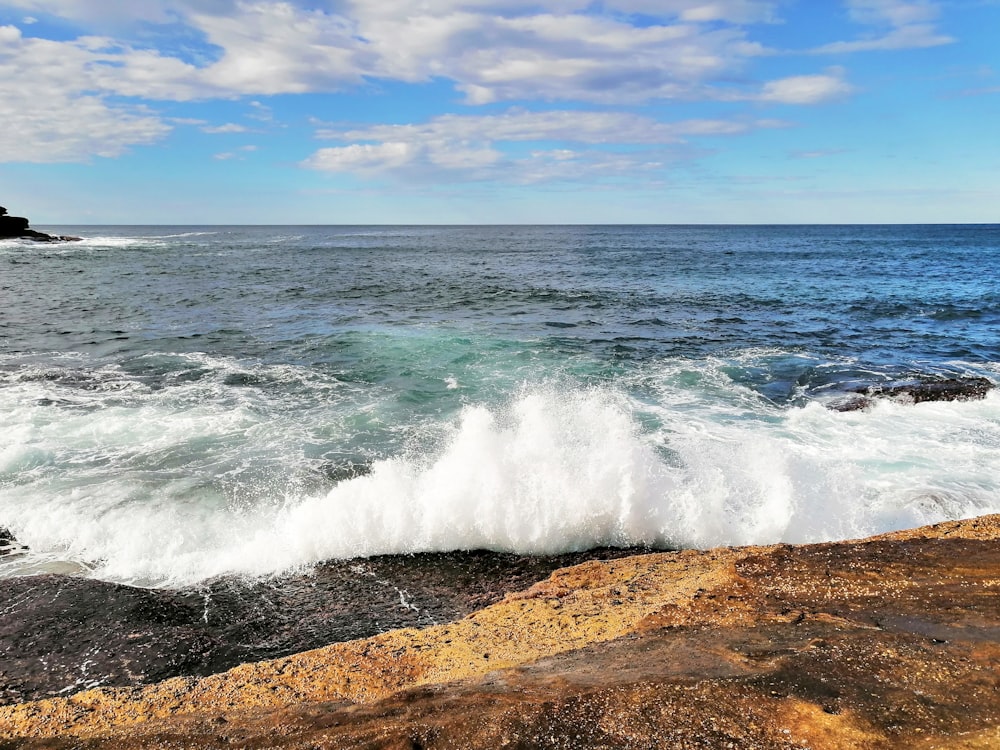 ocean waves crashing on shore during daytime