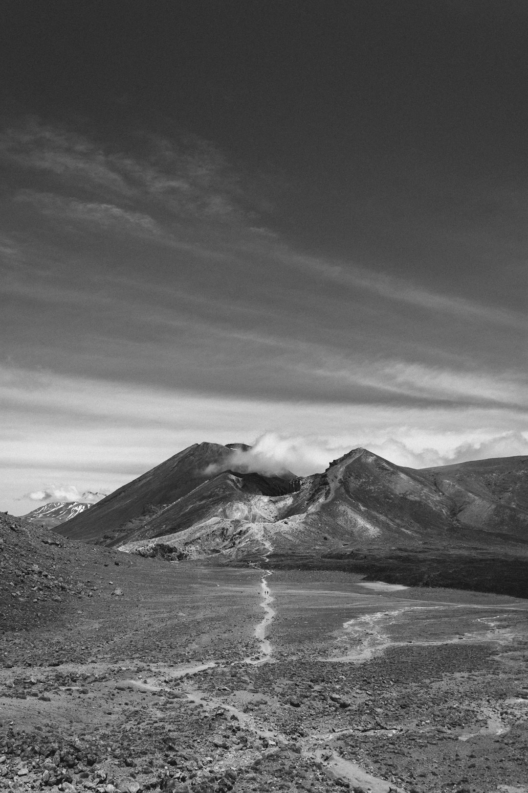 grayscale photo of mountain near body of water