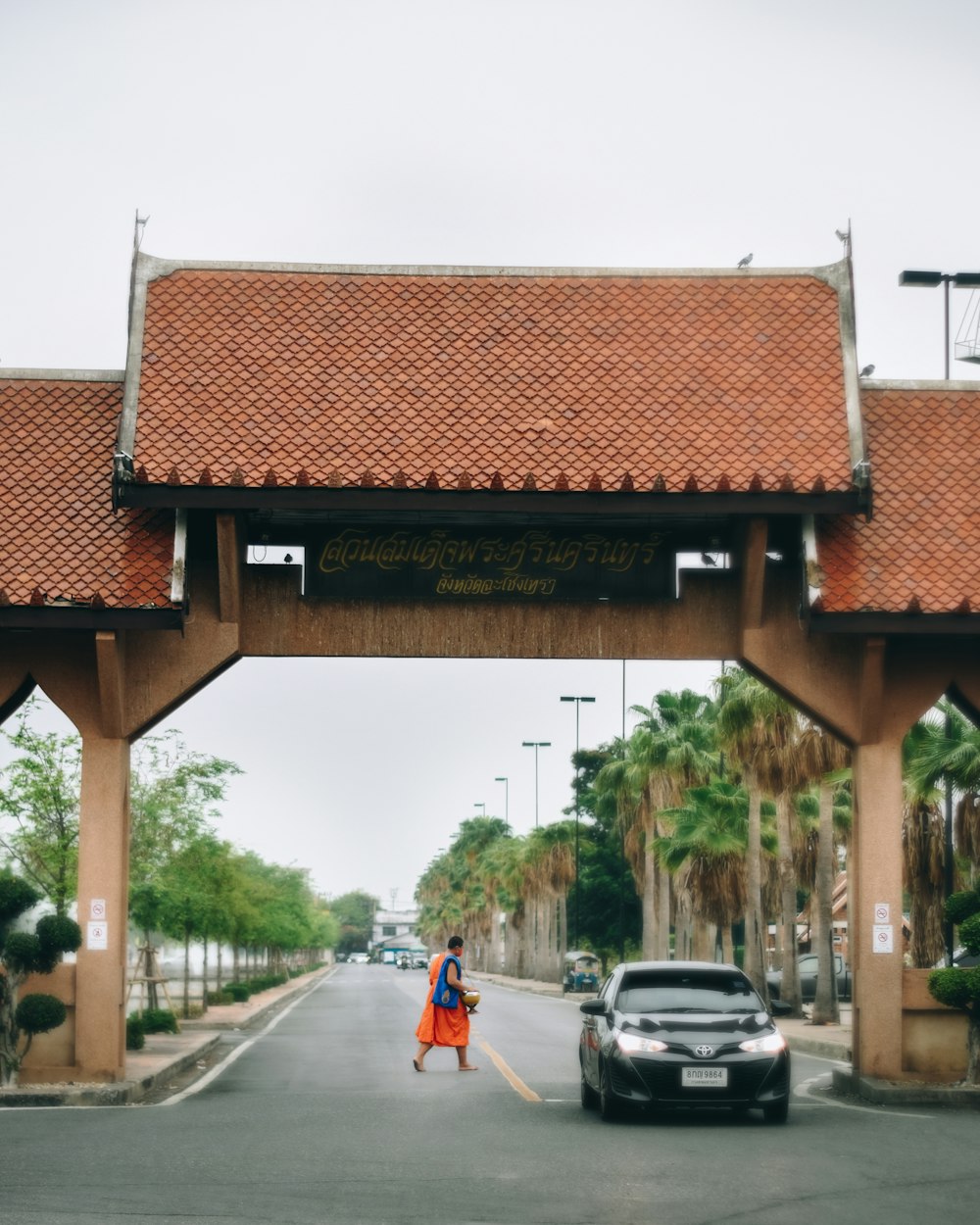 people walking on sidewalk near cars parked on roadside during daytime