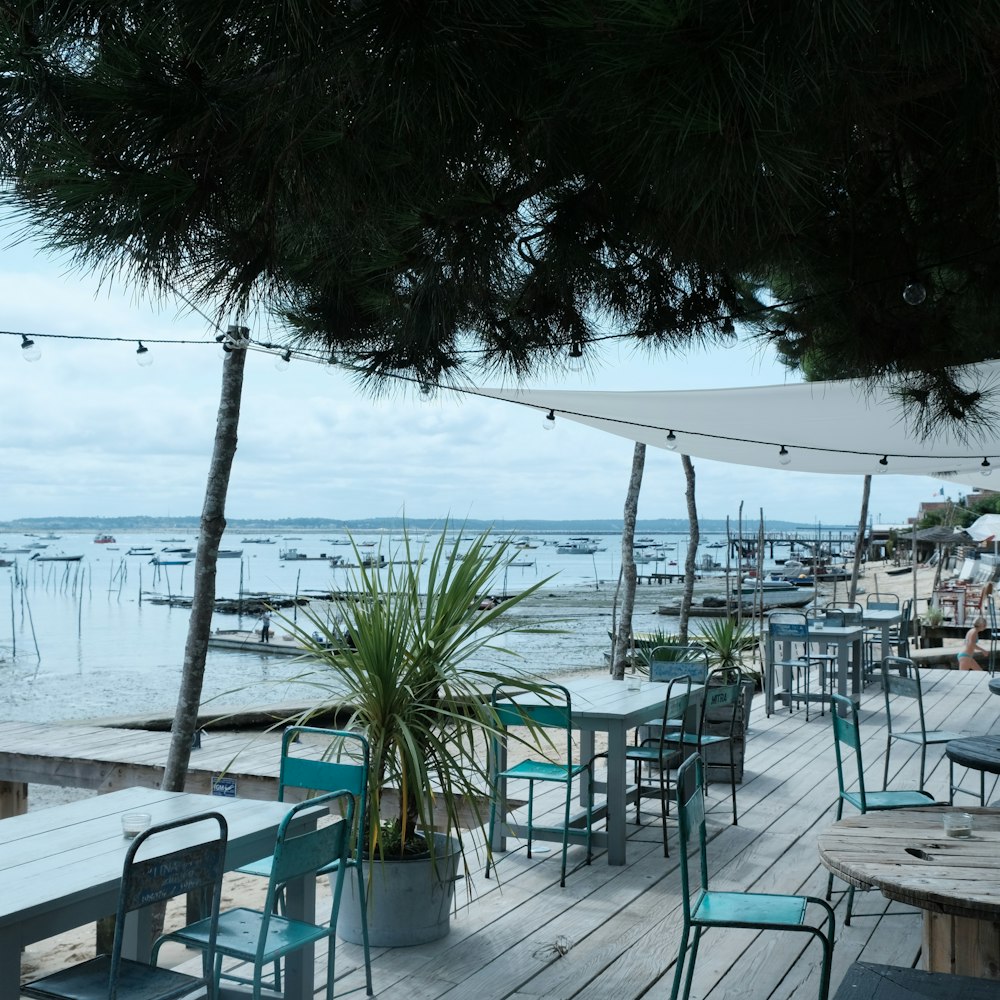 Sillas y mesas blancas y azules cerca del mar durante el día