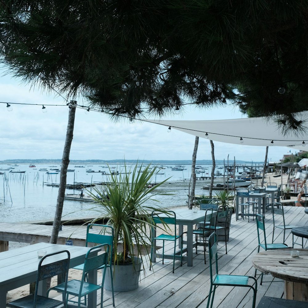 white and blue chairs and tables near sea during daytime