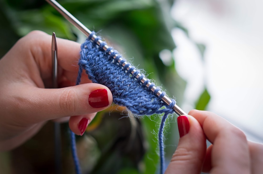 person holding blue and white yarn