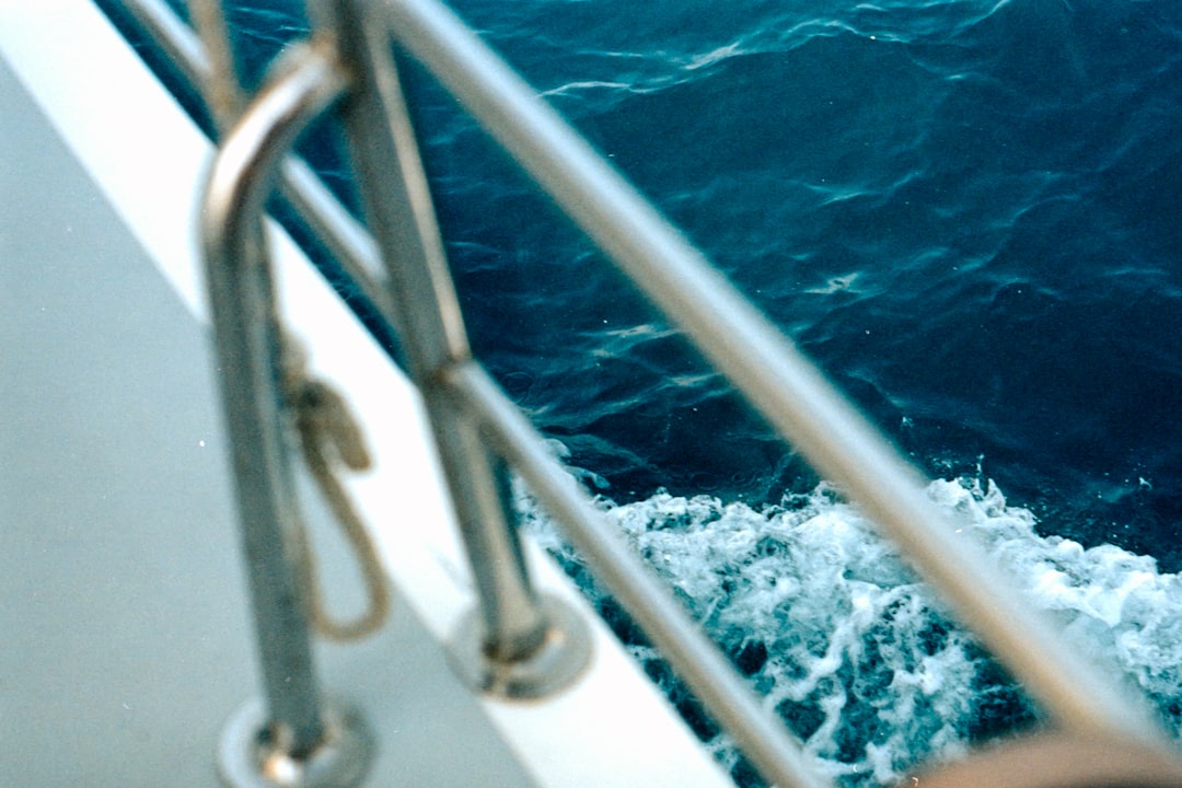 white metal railings near blue water