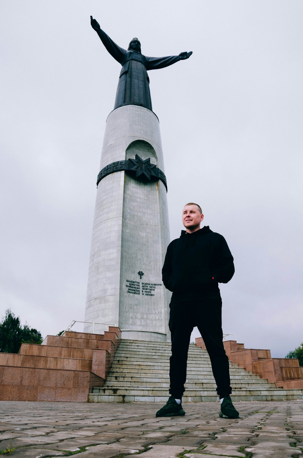 man in black jacket standing near gray concrete tower during daytime