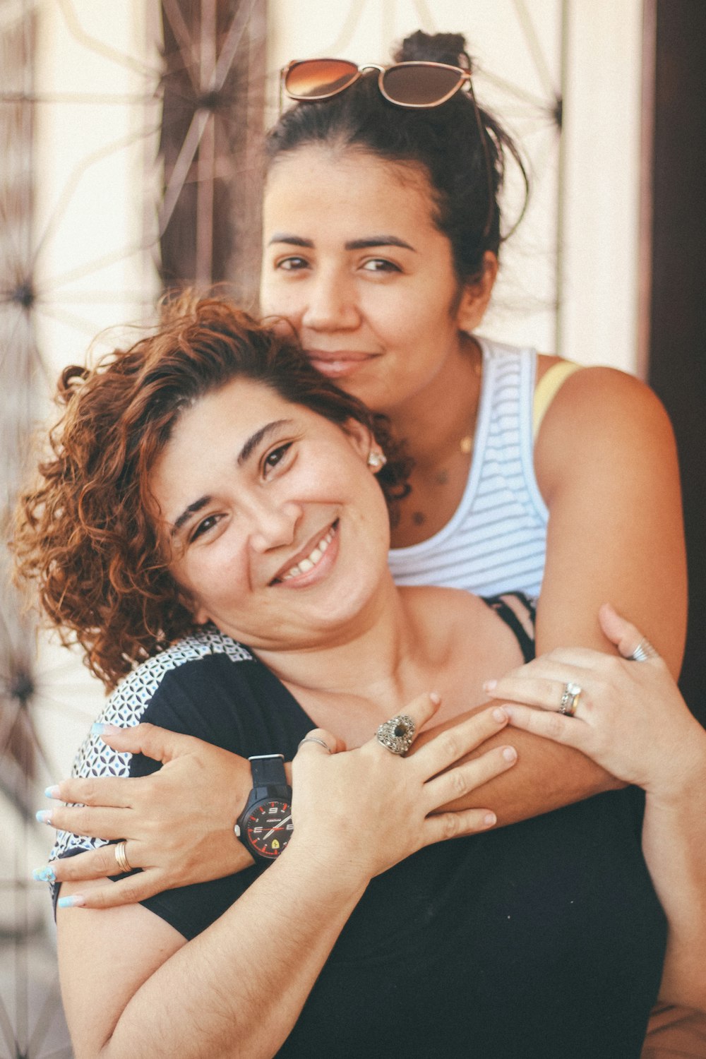 woman in white tank top hugging woman in blue tank top