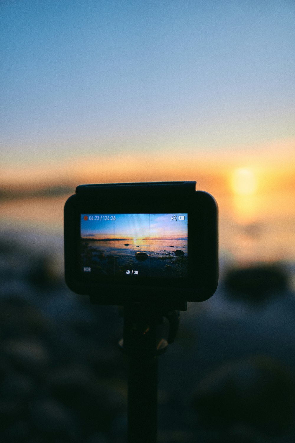 appareil photo reflex numérique noir prenant une photo du coucher du soleil