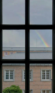 brown brick building under rainbow