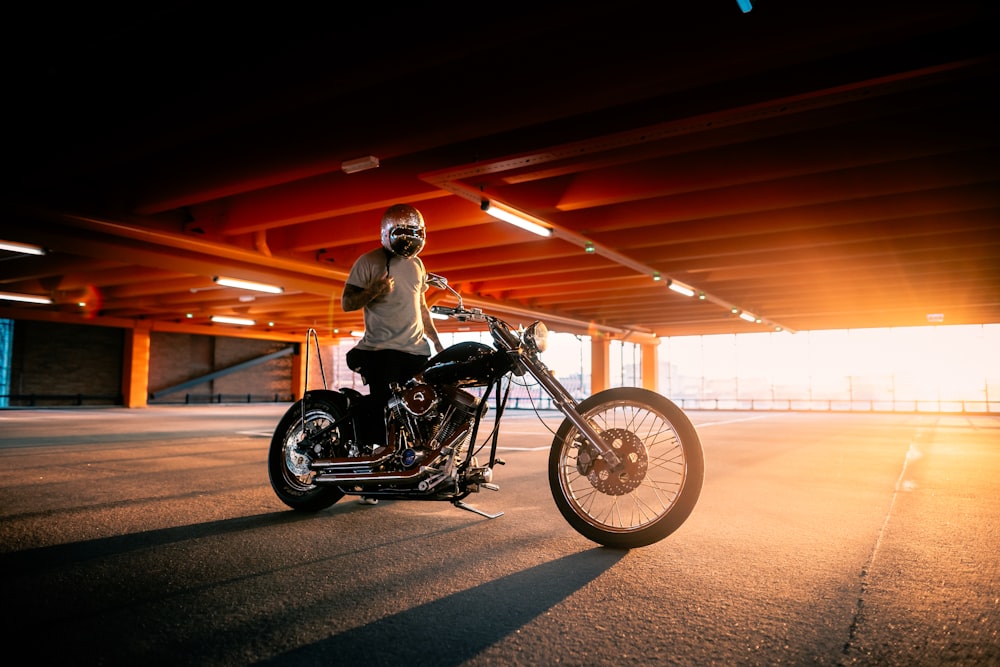 man in black jacket riding black cruiser motorcycle