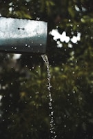 Rainwater flowing smoothly through a freshly cleaned gutter system during a light shower.