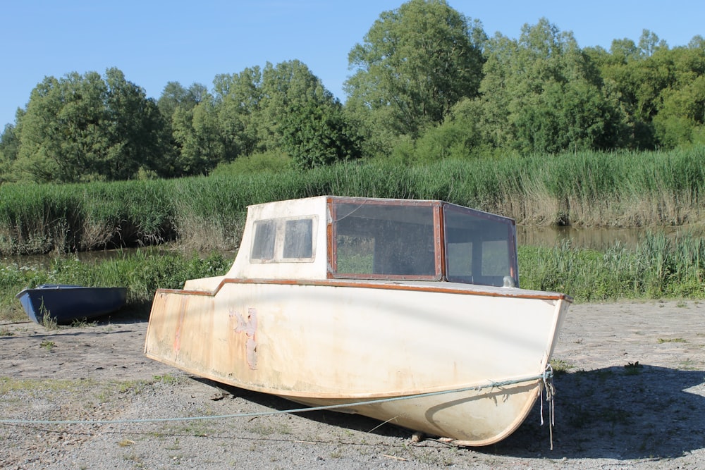 barco branco e marrom na areia cinzenta durante o dia