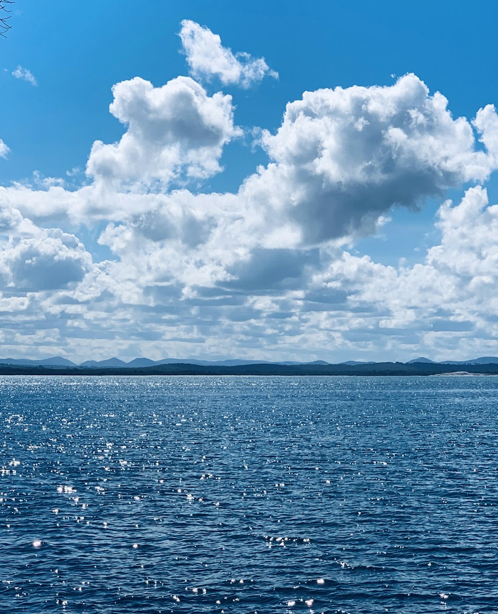 blaues Meer unter blauem Himmel und weiße Wolken tagsüber