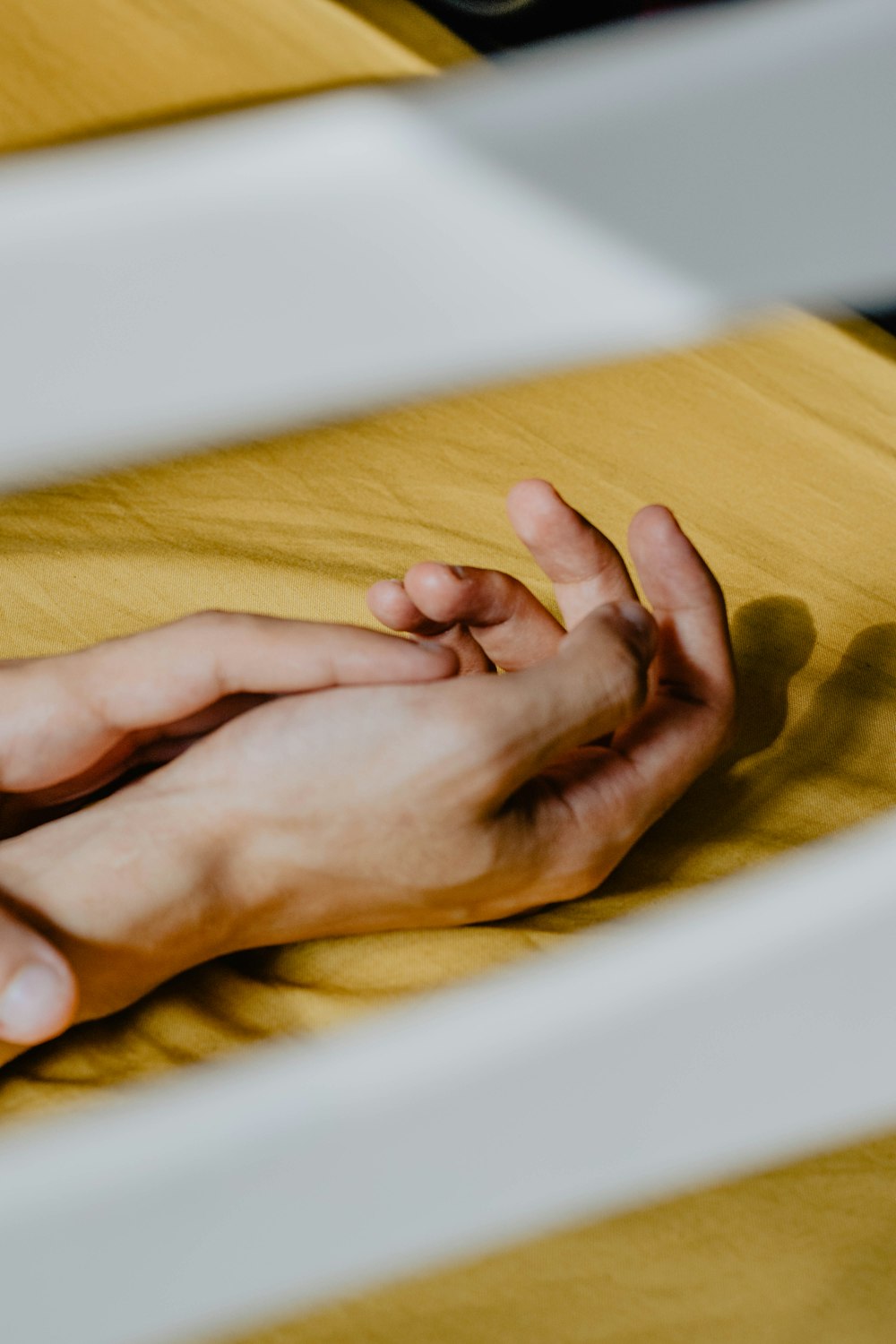 persons hand on yellow textile
