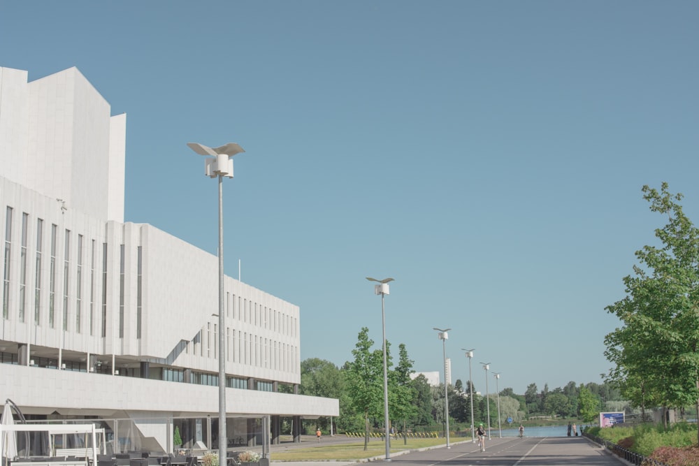 Weiße Straßenlaterne in der Nähe eines weißen Betongebäudes tagsüber