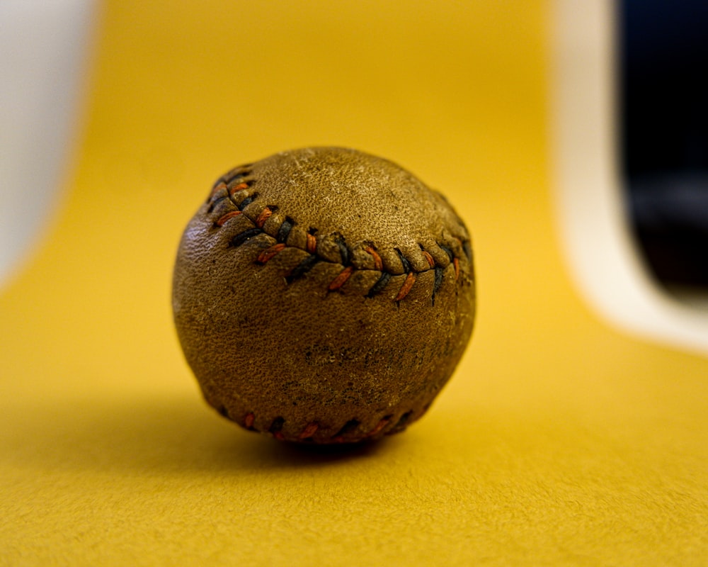 brown baseball on yellow table
