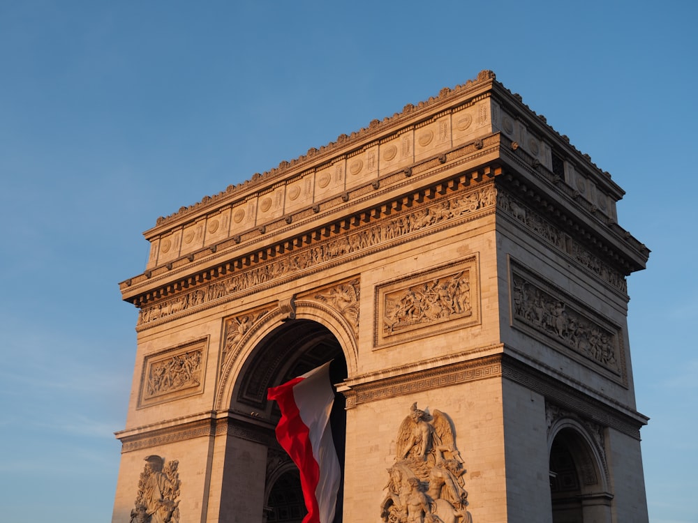 homme en chemise rouge debout près d’un bâtiment en béton brun pendant la journée