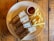 A plate of sandwiches with a creamy filling is served alongside a portion of golden French fries and a small cup of dipping sauce. The plate is placed on a rustic wooden table, adding a warm and inviting touch to the presentation.