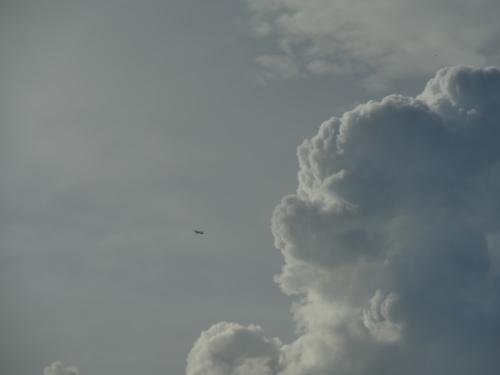 Un aereo che vola nel cielo con molte nuvole