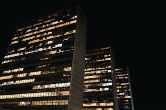 Evening view of a commercial building with illuminated windows symbolizing activity