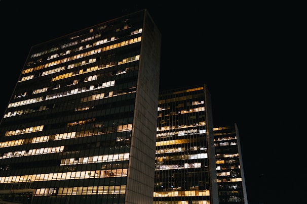 Evening view of a commercial building with illuminated windows symbolizing activity