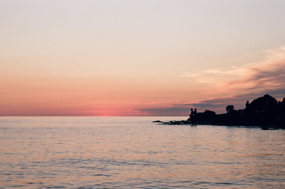 silhouette of people riding boat during sunset