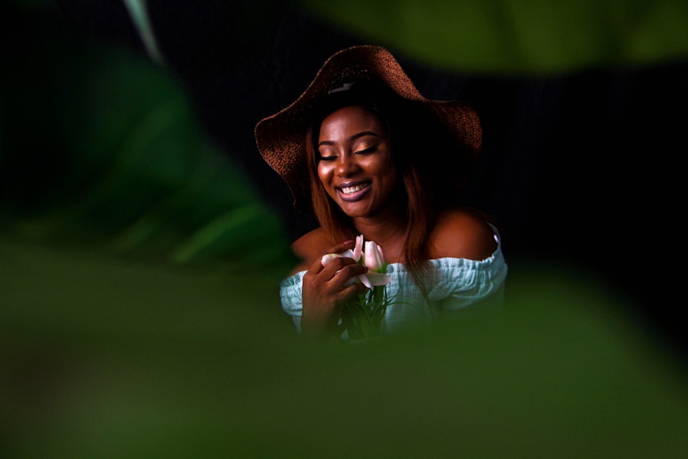 woman in white tank top wearing brown hat