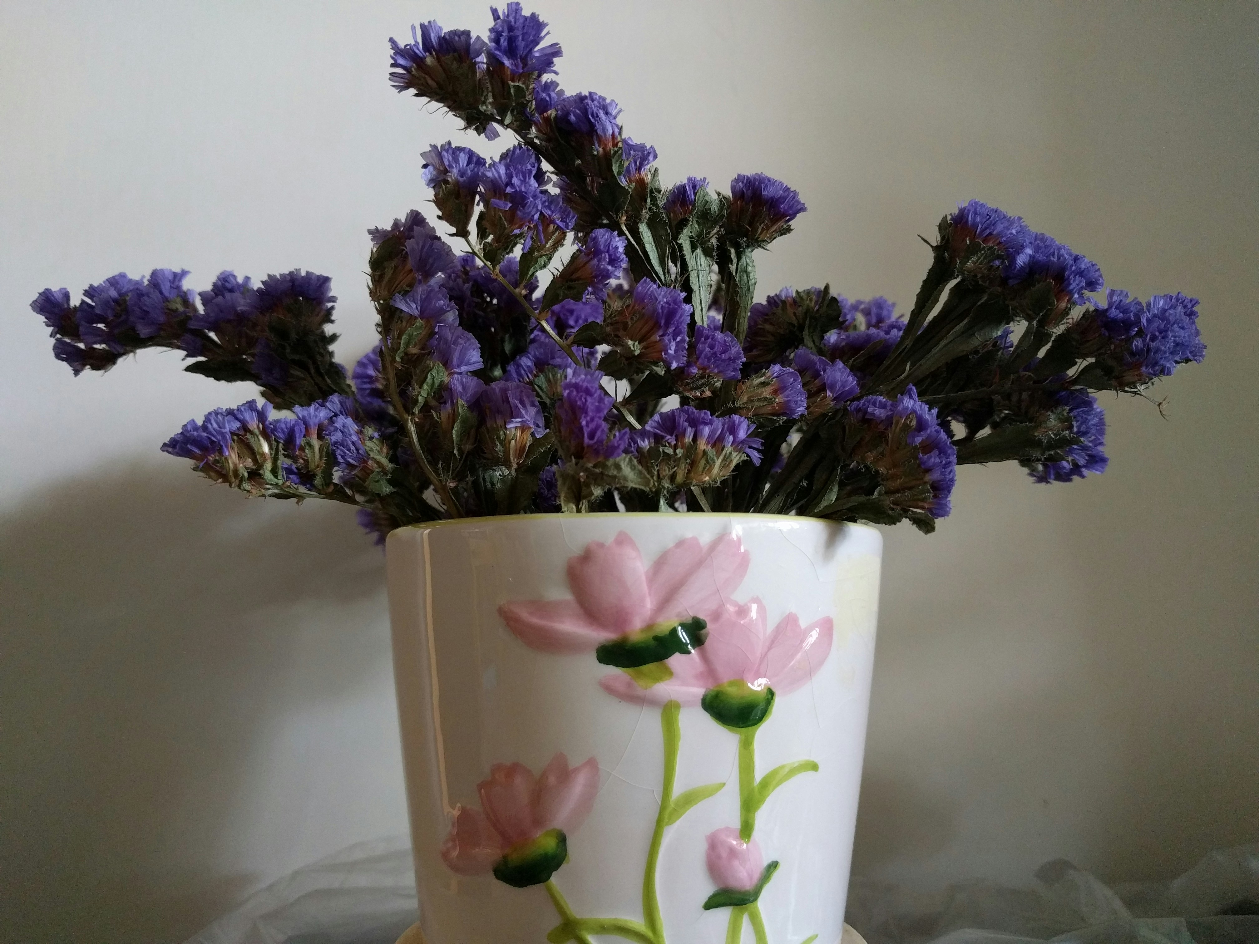 purple and white flower in white ceramic vase