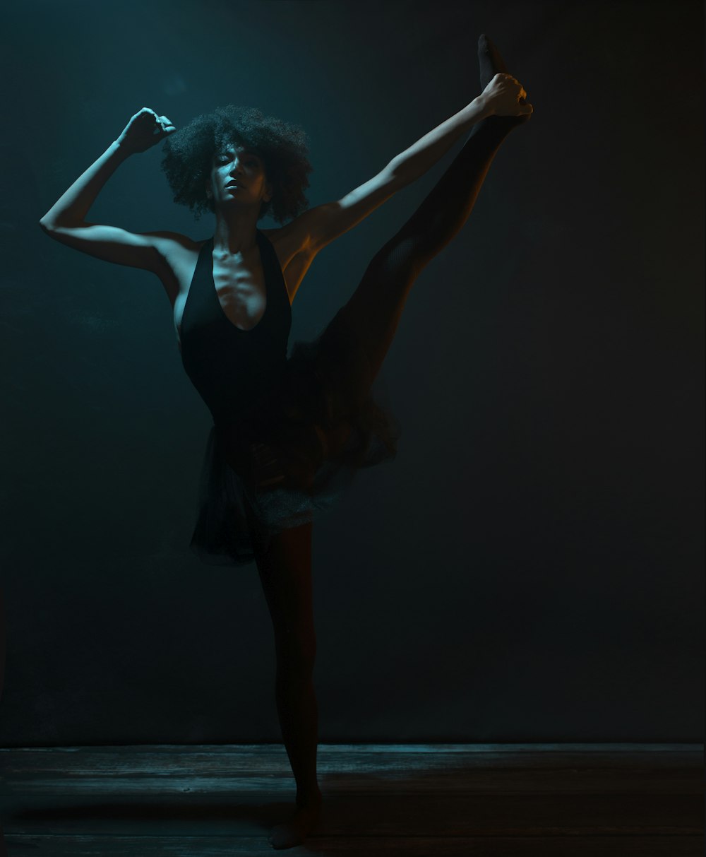 woman in black tank top and black skirt raising her hands