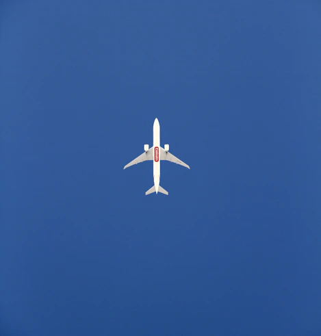 an airplane is flying in the blue sky