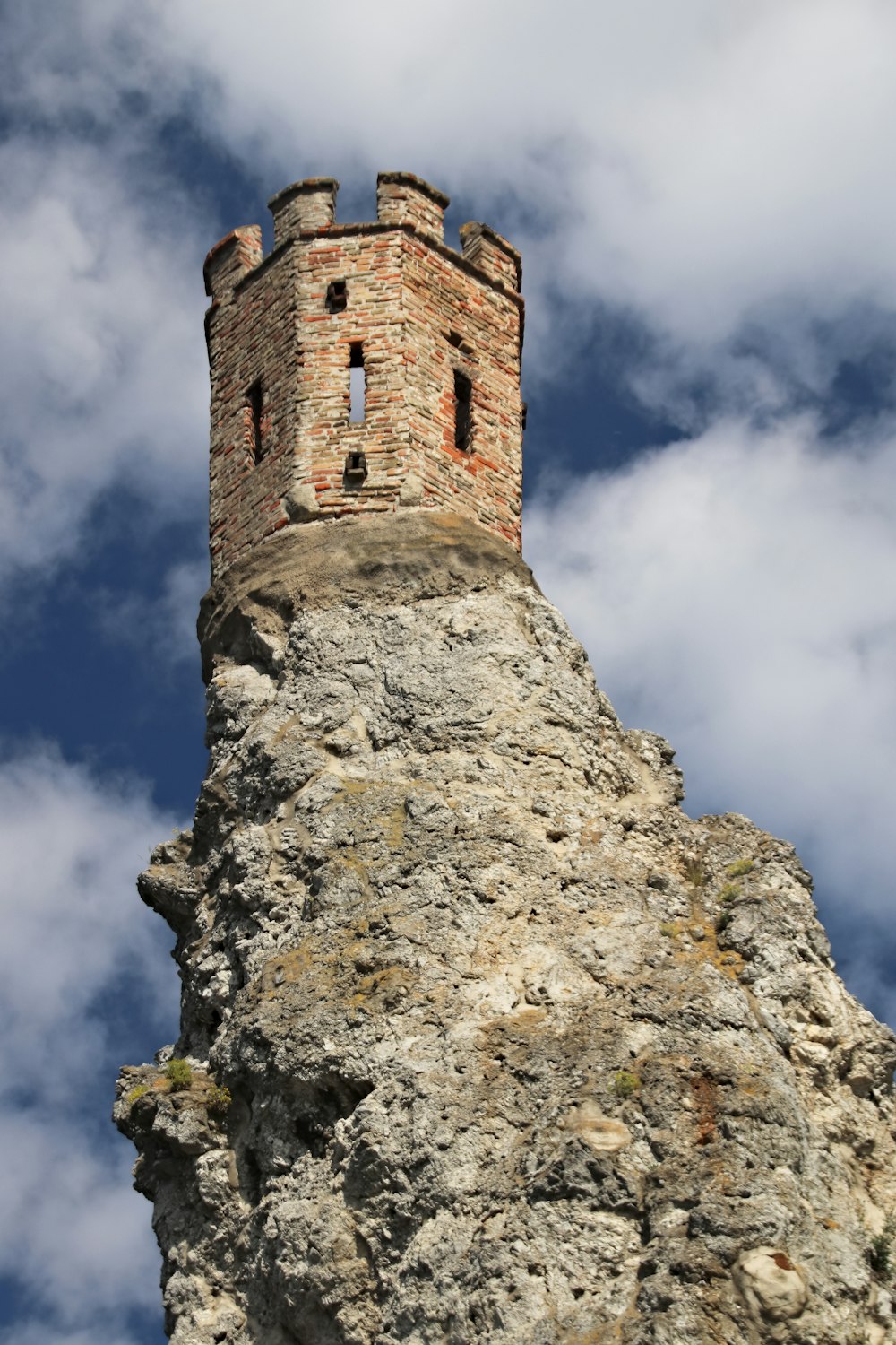 brown brick tower under cloudy sky