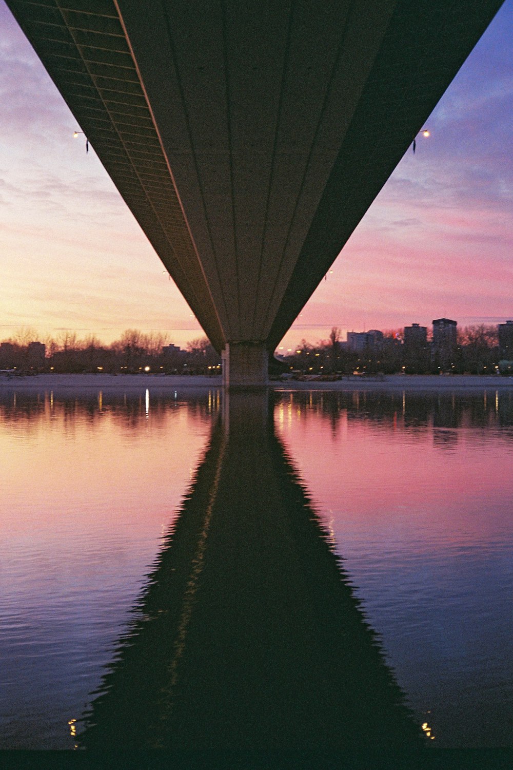 silhouette of building near body of water during sunset