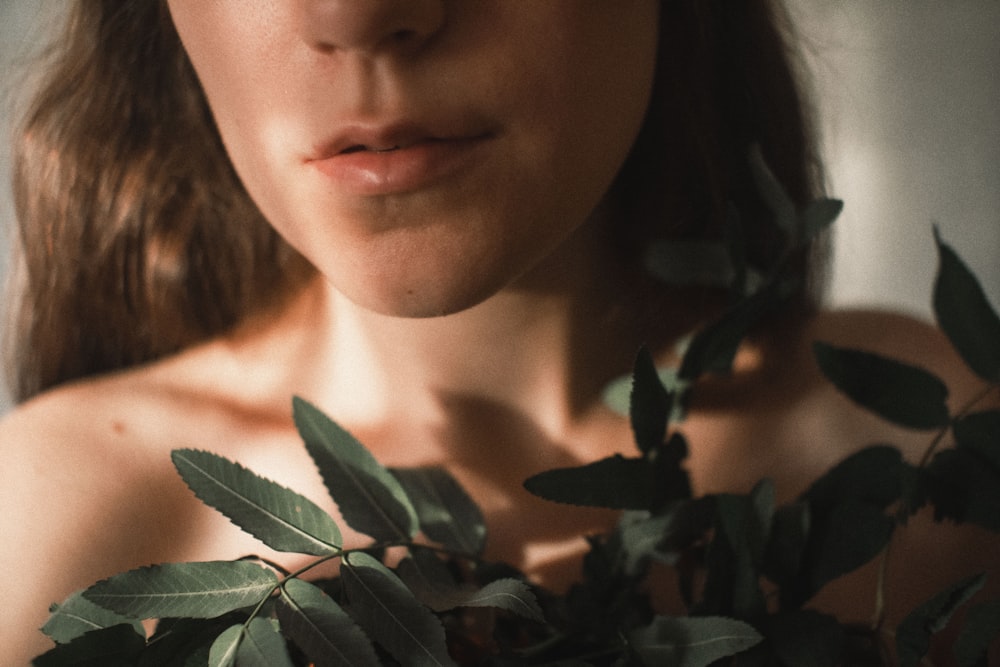 woman in black shirt holding green leaves