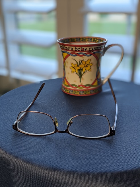 Close-up of a pair of Equinox blue blockers resting on a sleek wooden table beside a wellness journal and a cup of herbal tea.
