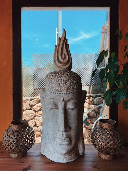 gray concrete statue near green plants during daytime