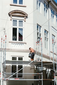 man in black t-shirt and black shorts sitting on black metal railings during daytime