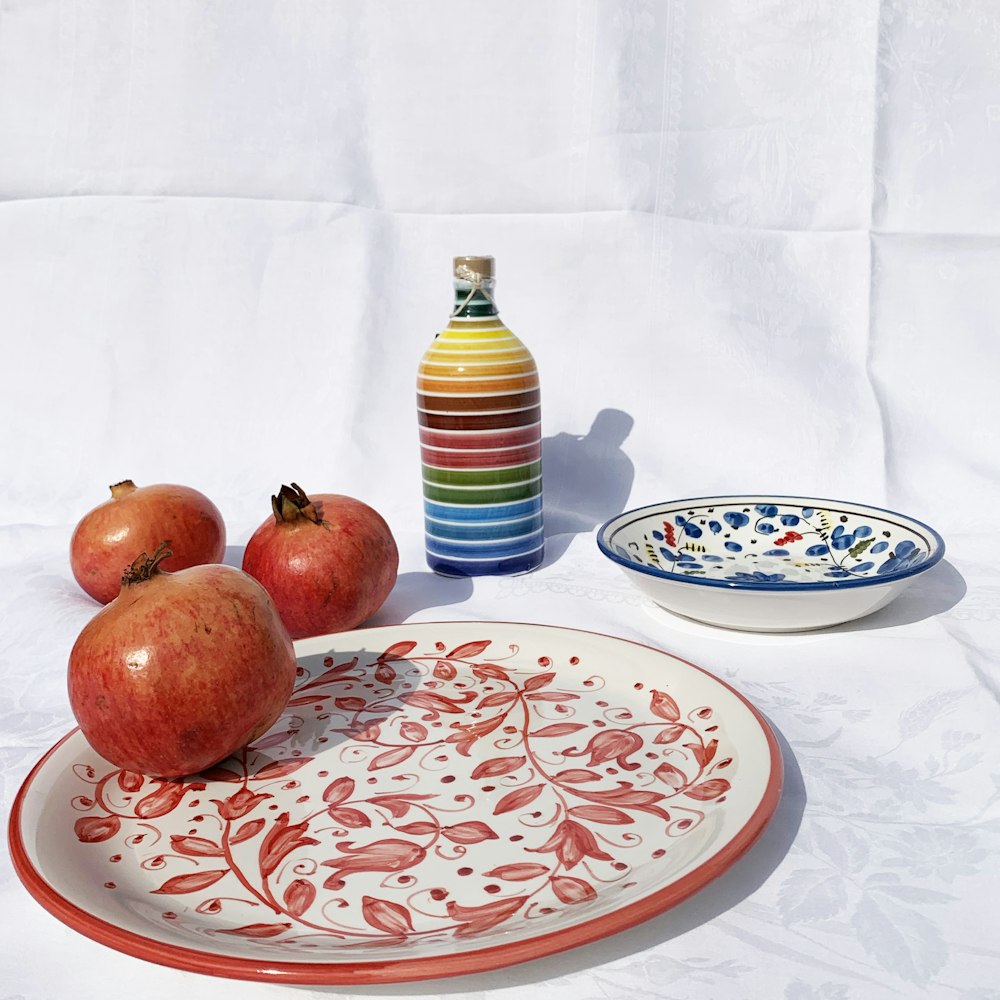 red apples on white and blue floral ceramic plate