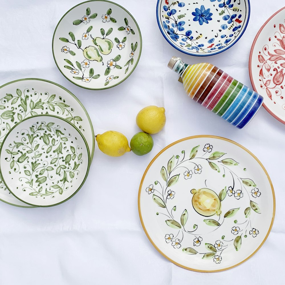 yellow lemon on white and green floral ceramic plate