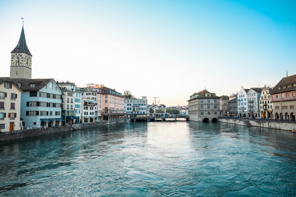 specchio d'acqua tra gli edifici sotto il cielo blu durante il giorno