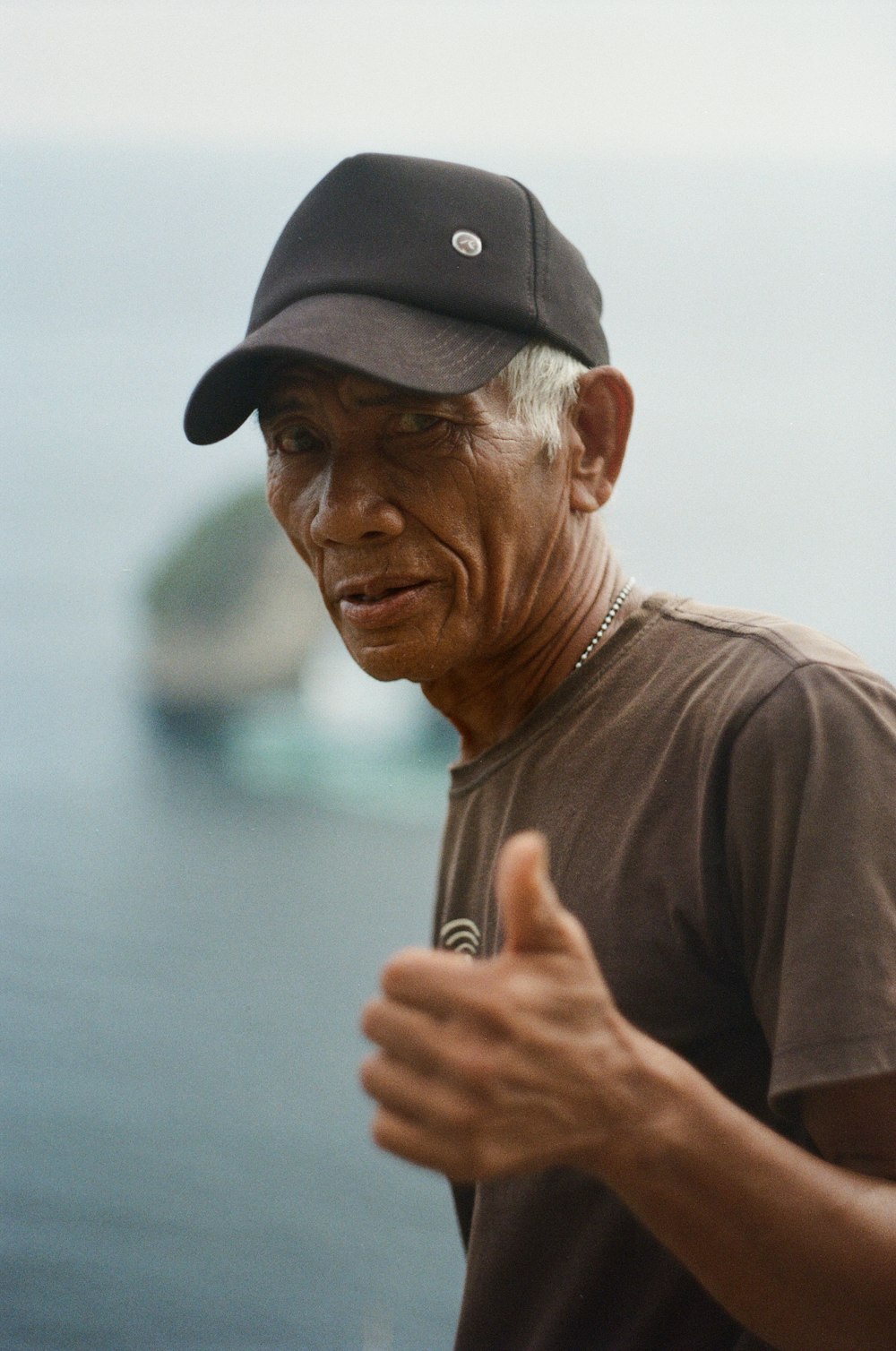 homme en t-shirt à col rond marron portant une casquette noire