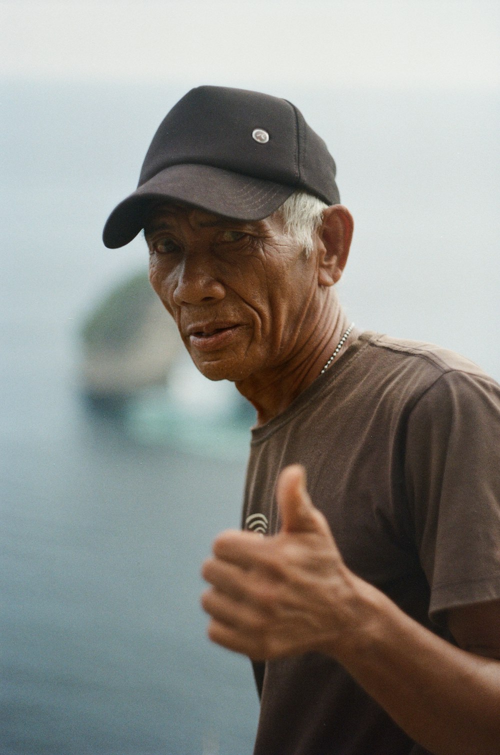 man in brown crew neck t-shirt wearing black cap