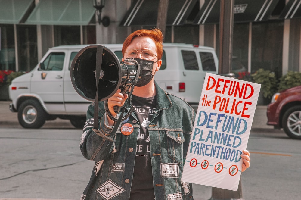 man in black leather jacket holding black dslr camera