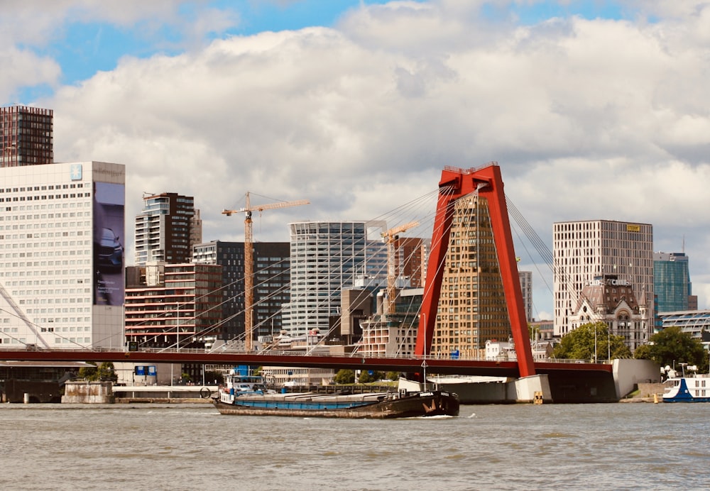 white and red boat on water near city buildings during daytime