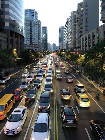 cars on busy city road with tall building during daytime