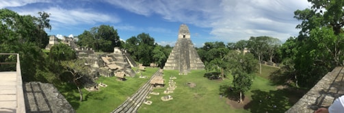 A panoramic view of the ancient Mayan ruins of Chichen Itza surrounded by lush jungle.